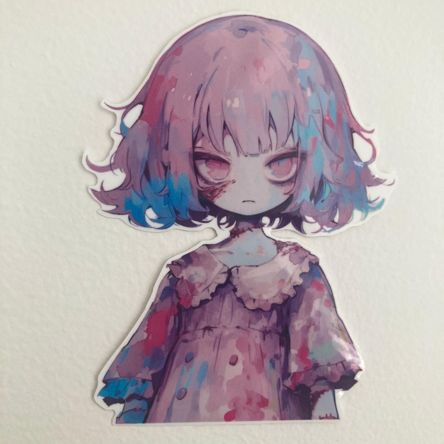 A sticker of an anime character with purple and blue hair and a ruffled dress, placed on a plain light background. The character has a somber expression and soft, pastel colors.