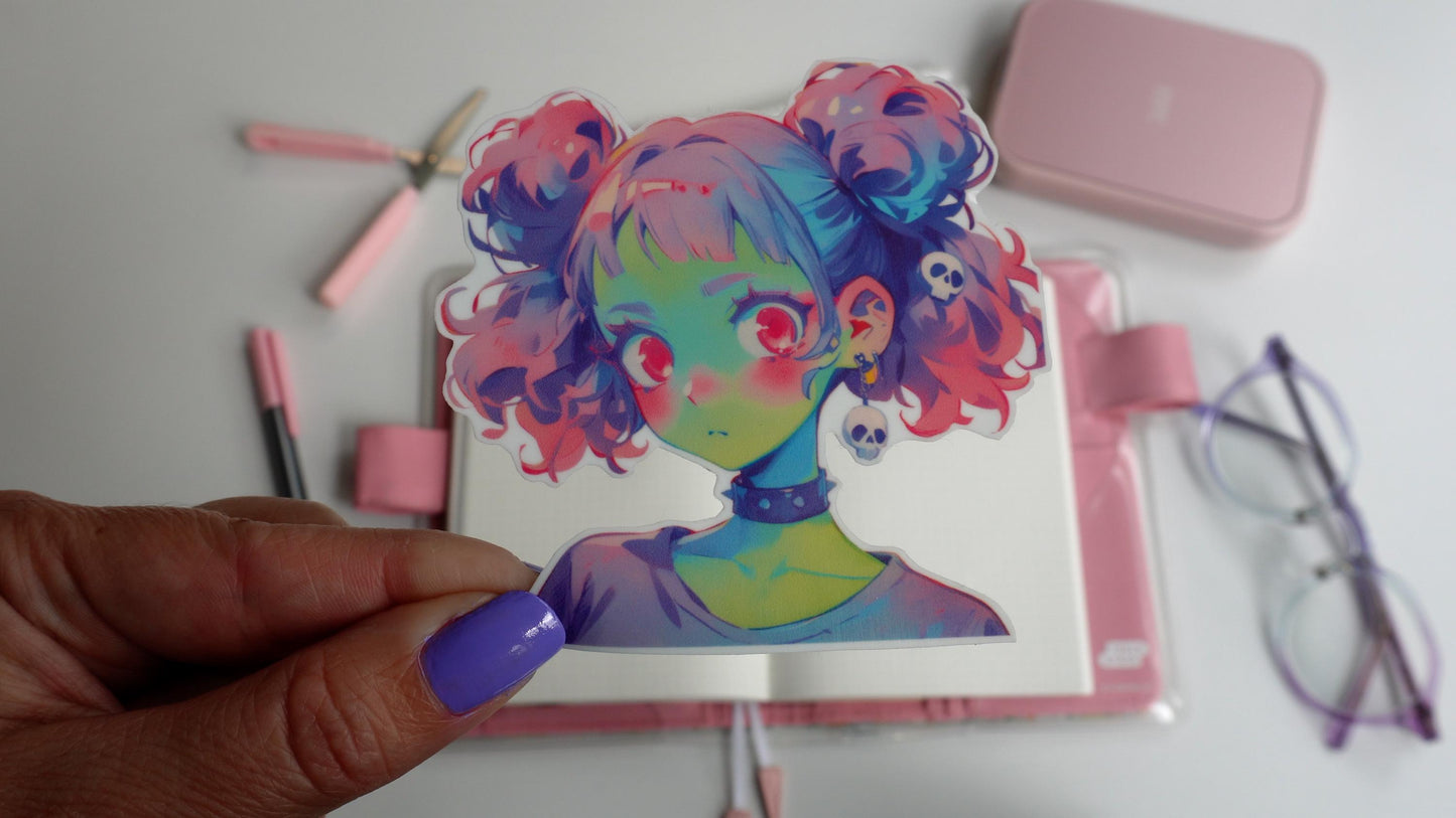 Sticker of an anime-style character with pastel pink and blue twin buns, green skin, and wide pink eyes. The character wears a black choker and skull earrings. The sticker is held by a hand with purple-painted nails.