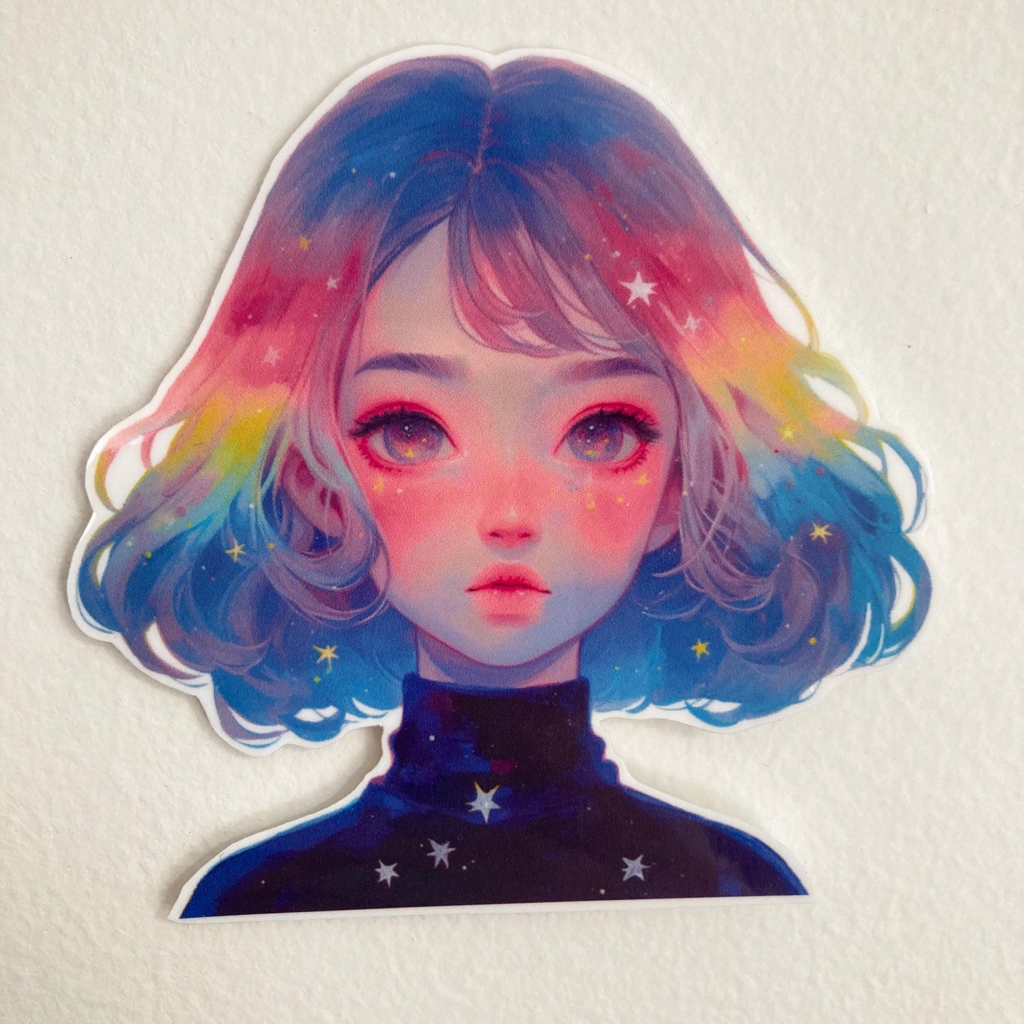 A colorful sticker of a person with pastel rainbow hair and vibrant eyes, wearing a galaxy-themed shirt with star patterns, set against a plain white background.