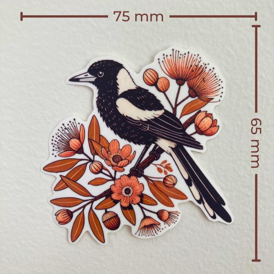 A sticker of a black-and-white magpie perched on a branch with orange flowers and leaves is shown against a white background. Brown measurement lines indicate the sticker’s dimensions: 75 mm wide and 65 mm tall.