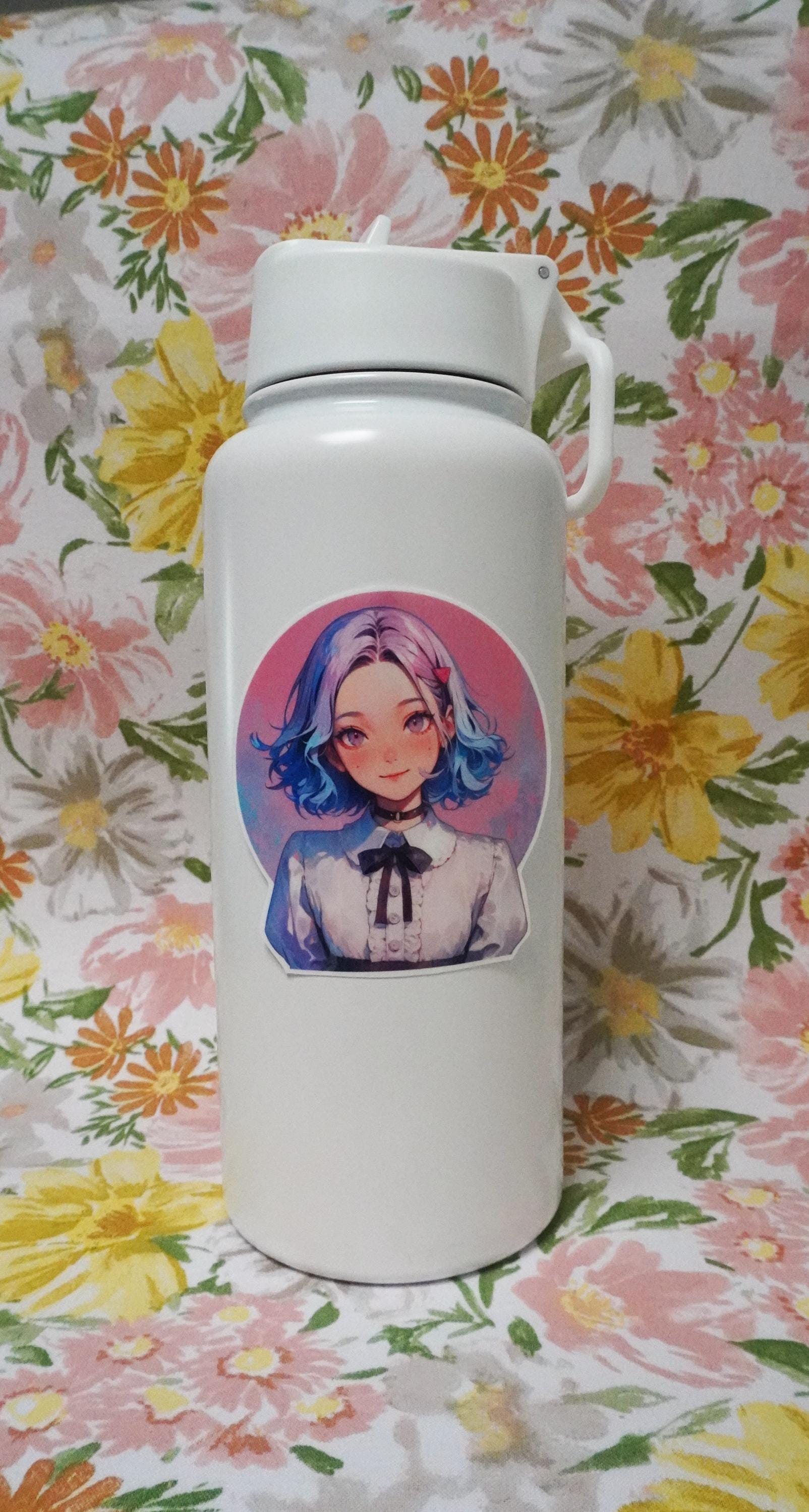 A white bottle decorated with a round anime-style sticker of a smiling character with short blue and pink hair, wearing a white blouse with a black bow. The background is pink, and the bottle is set against a floral-patterned backdrop.