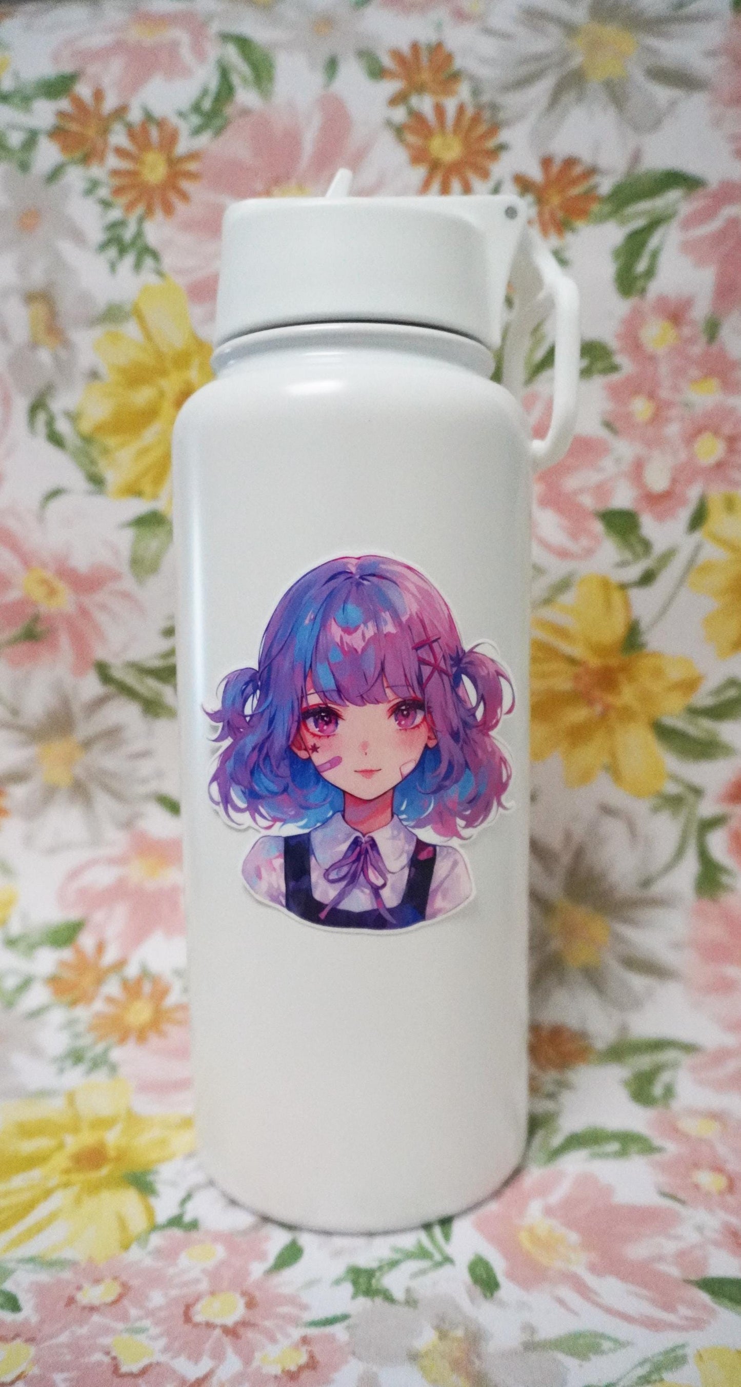 A white bottle with a sticker of an illustrated girl with short wavy hair in blue and pink tones, wearing a collared blouse with a bow. The background is a floral pattern with large yellow, pink, and green flowers.